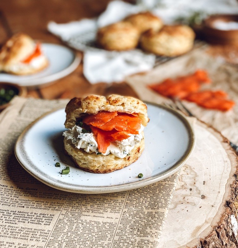 Feta chive buttermilk biscuit on a plate over newspaper